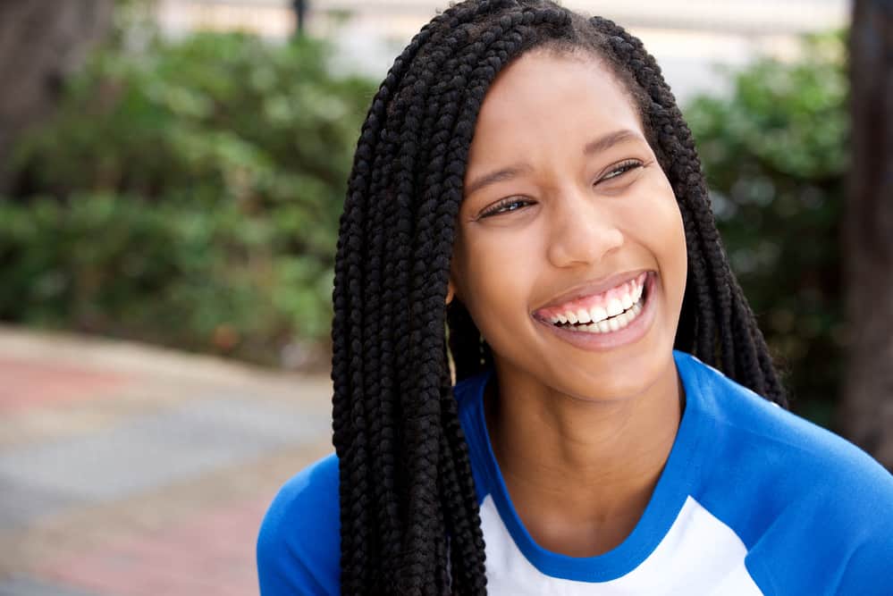 Young black girl sitting outside during swim season with her hair braided