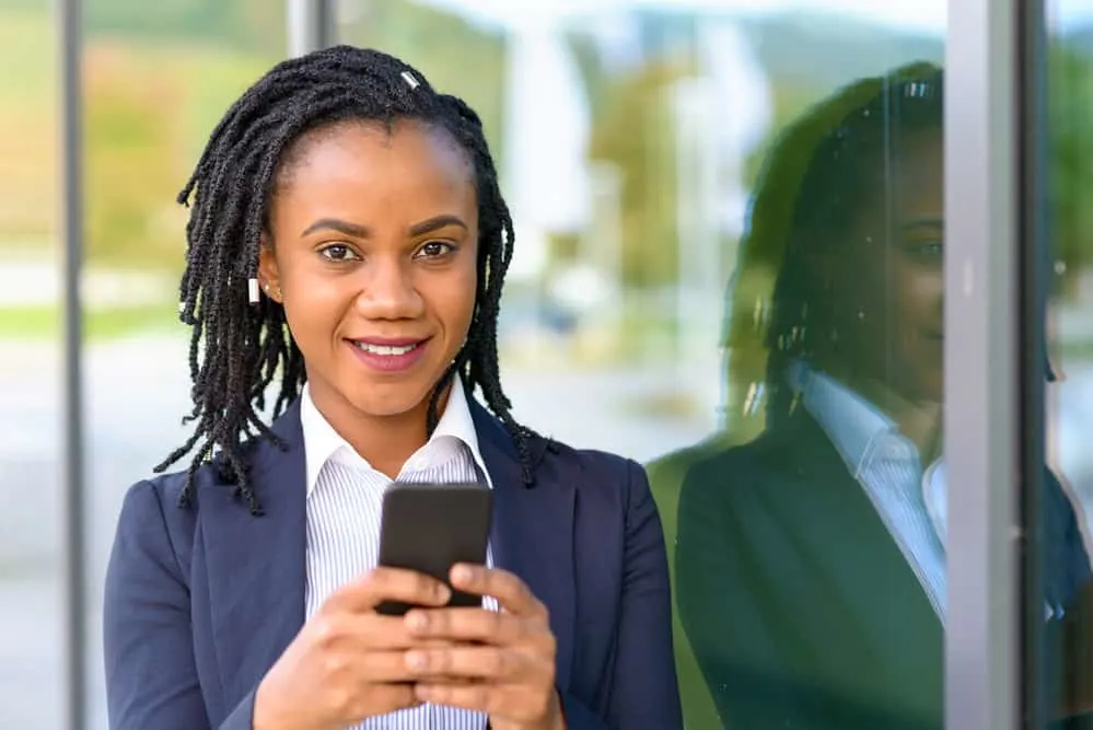 The 5 Different Stages of Locs: Baby, Budding, Teenage, Mature, and Rooted 5 African American girl with budding phase locs started with two-strand twists wearing a business suit