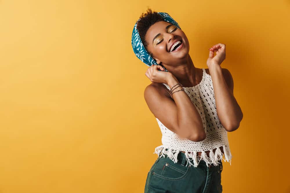 African American woman dancing while wearing a satin head scarf to keep her scalp moisturized