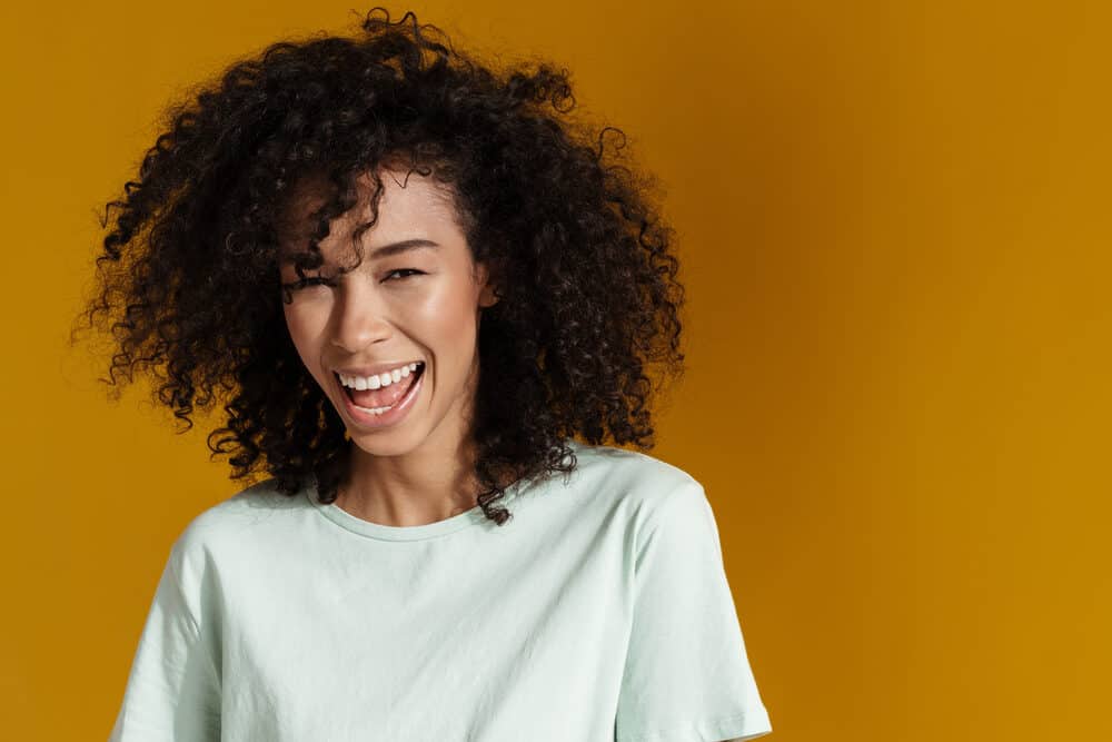 Pretty African American woman with low porosity hair that uses minimal heat to maintain her curls