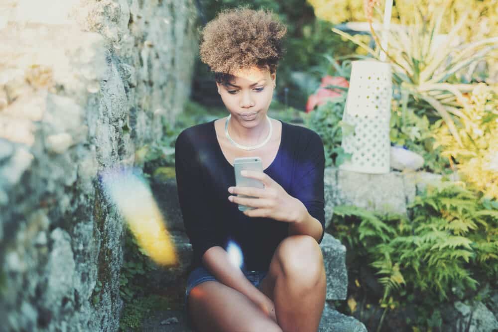 Lovely young black female making funny faces while taking a photo