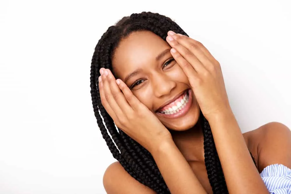 A cheerful black lady after using leave-in conditioner on her braided curls