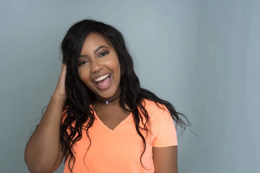 Are Dominican Hair Salons Good for Black Hair? Do They Damage Your Hair? 4 Black girl from the Dominican Republic smiling inside a New York City building