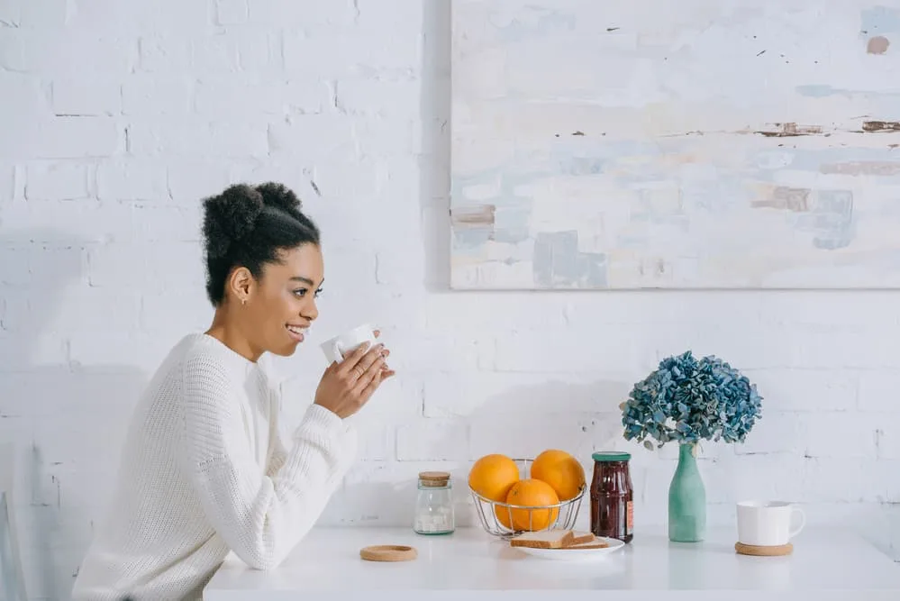 Afro Puffs Tutorial: ‘How to Do' Styling for Natural Hair: Complete Guide 7 Lady drinking coffee at breakfast wearing a flat twist style on kinky hair