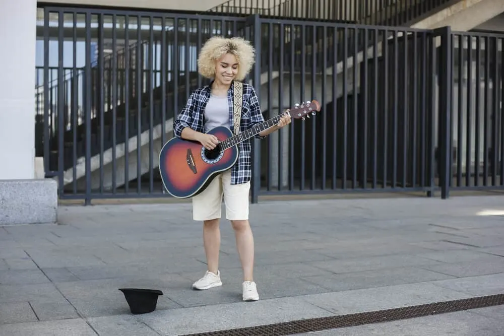 Putting Ash Blonde Over Bleached Hair: Can You Do It? What Happens? 4 Female street musician with light ash blonde hair getting ready to perform at a concert