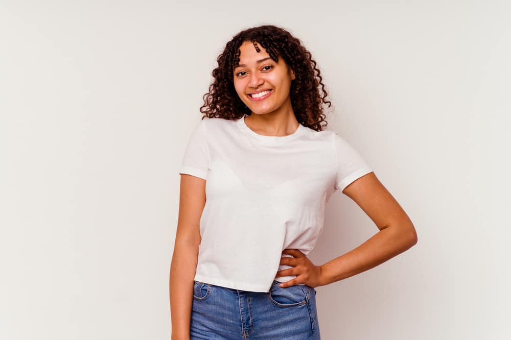 Cute light-skinned black girl wearing casual clothes with eyelash extensions and curly hair strands