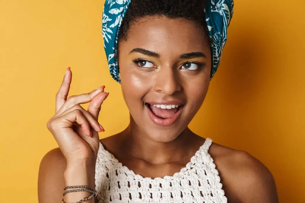 Black girl snapping her fingers after find a new medicated shampoo for treating dandruff