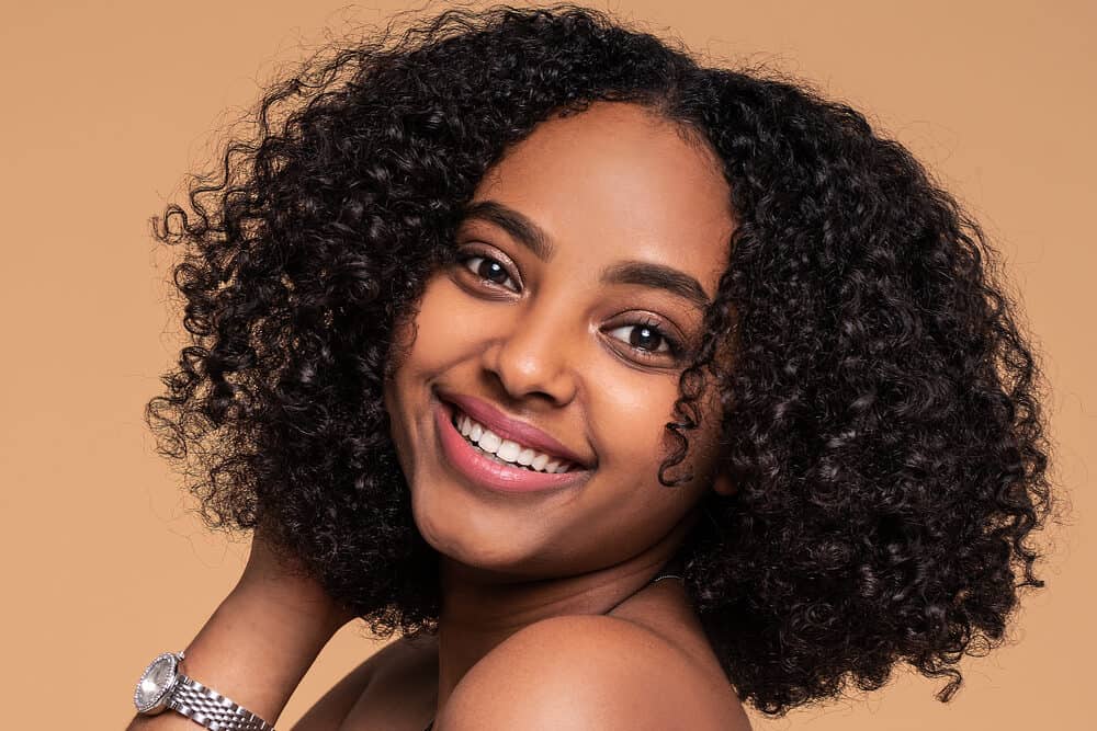 African woman with a curly afro hairstyle on type 3c hair strands