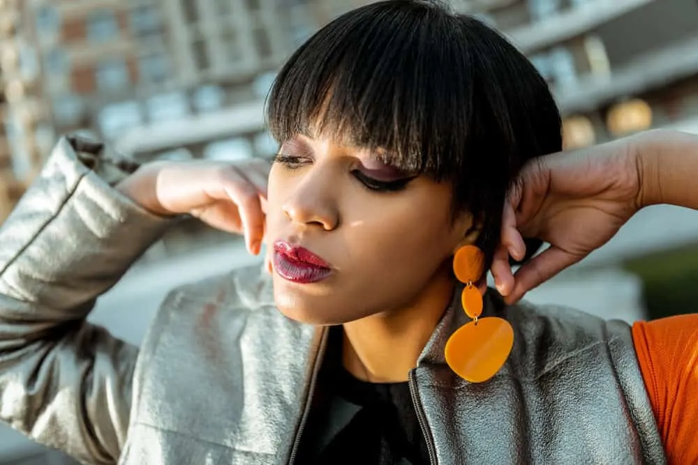 How to Fix a Bad Layered Haircut Yourself: DIY Step-by-Step Tutorial 10 Dark-haired lady with a bad haircut with existing layers wearing orange plastic earrings