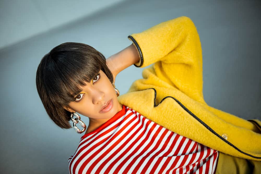 Black girl with brown eyes with bad layers and unwanted bangs wearing red and white strips