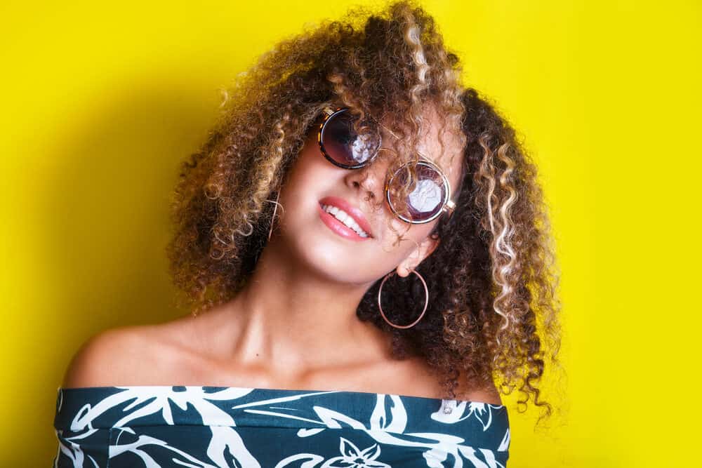 Cute mixed girl wearing sunglasses with loose spiral curls and natural waves