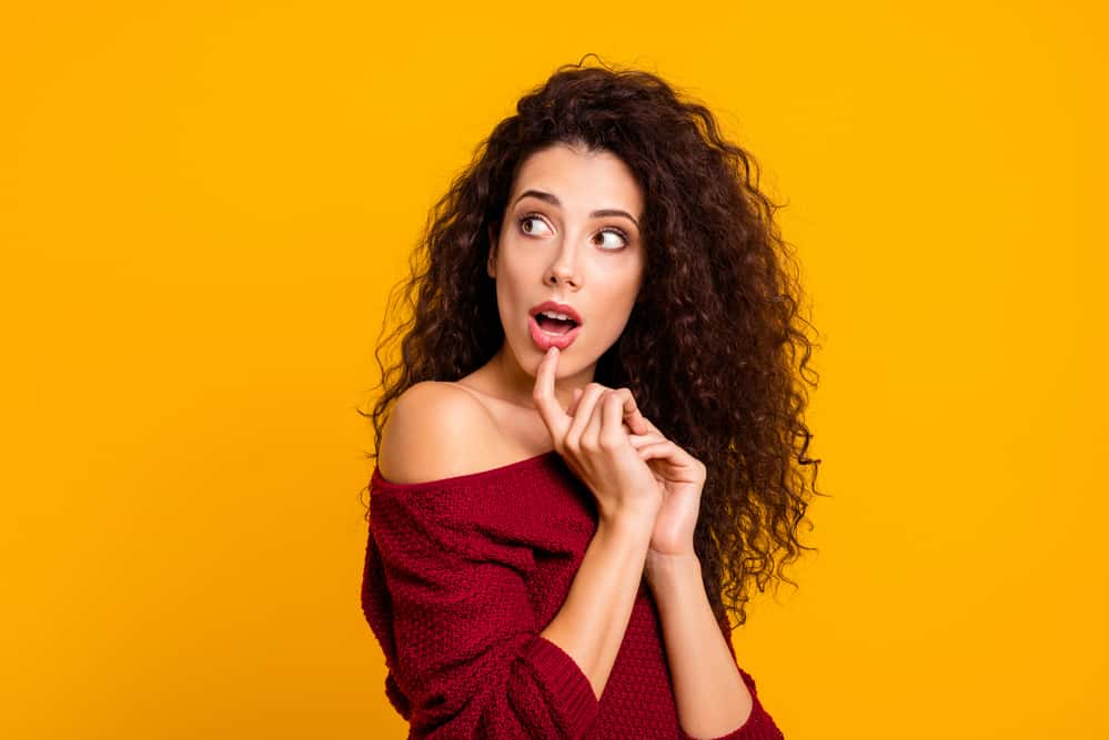 Female with a partial perm and tousled waves with subtle highlights and a surprised look on her face