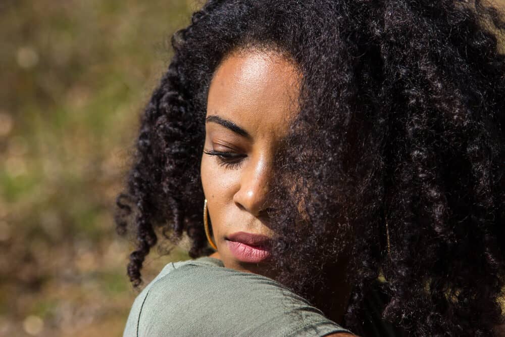 Cute African American girl with a manageable hair structure sitting outside on a fall day