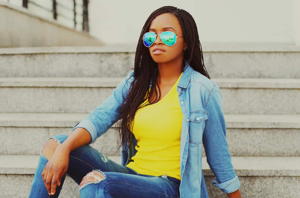 Cute black girl with natural black hair covering her own hair with Marley hair braids