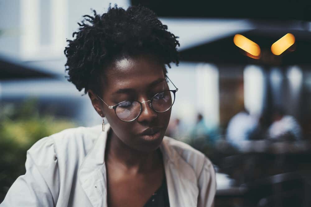 Young black woman with curly hair wearing single strand plaints, a common style that women with natural hair wear