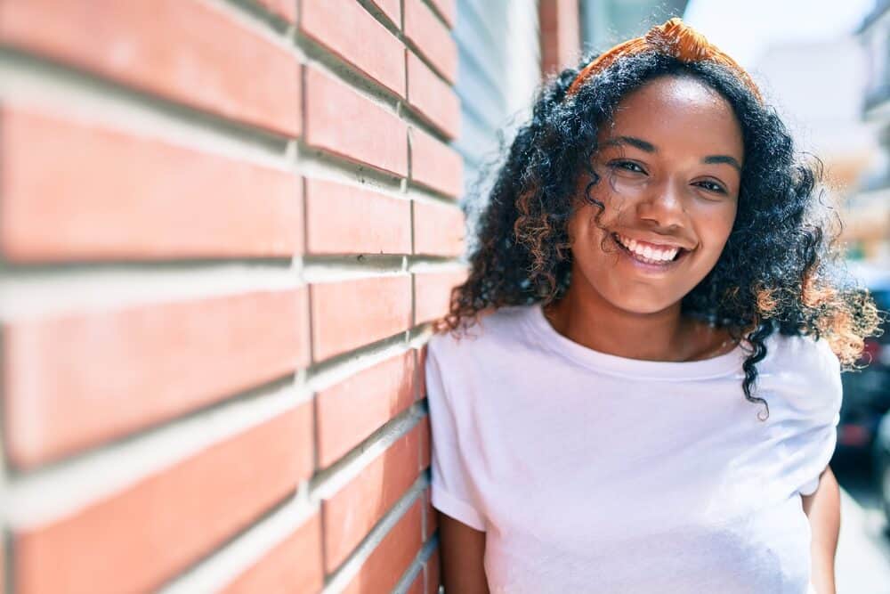 Young black girl with medium length hair wearing a big smile showing off her female attractiveness
