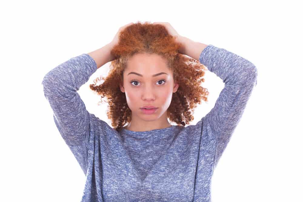 A mixed-raced adult female of Celtic descent with curly red hair; it's uncommon to see ginger hair on black women