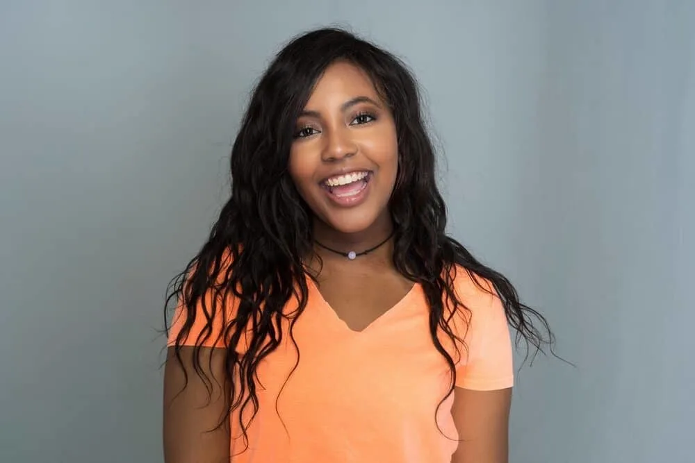 Are Dominican Hair Salons Good for Black Hair? Do They Damage Your Hair? 6 Cute female with a Dominican blow-out hairstyle and a big smile