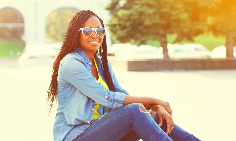 Female at the beach wearing braids which is the best protective hairstyle for getting hair wet