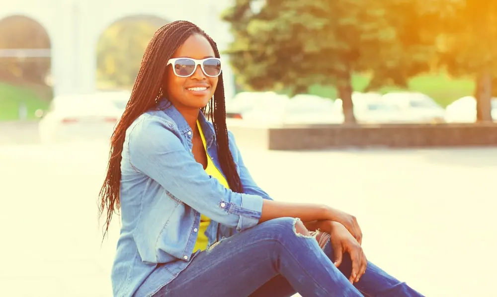 5 DIY Protective Hairstyles That Can Get Wet for Natural Hair 5 Female at the beach wearing braids which is the best protective hairstyle for getting hair wet