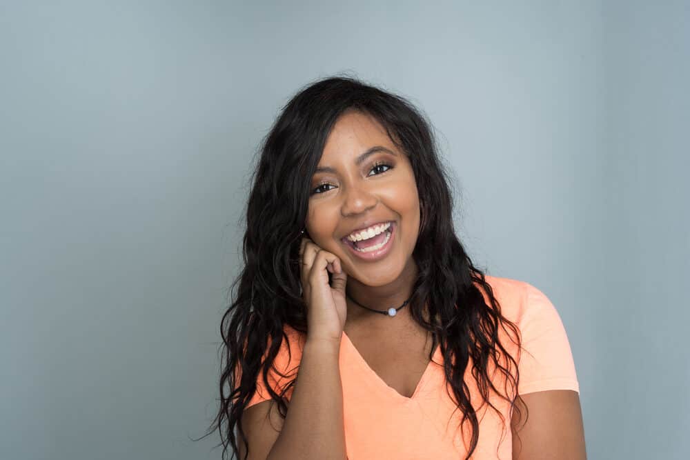 Black lady wearing a t-shirt and black necklace with a relaxer treatment