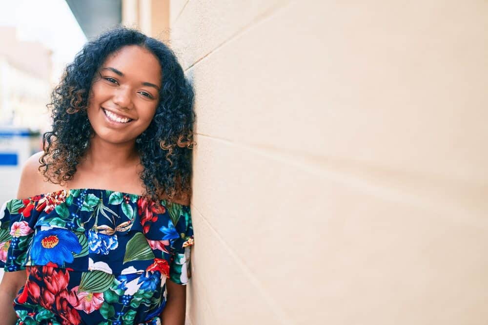 A beautiful black woman that's a physical beauty with longer hair than most curly girls