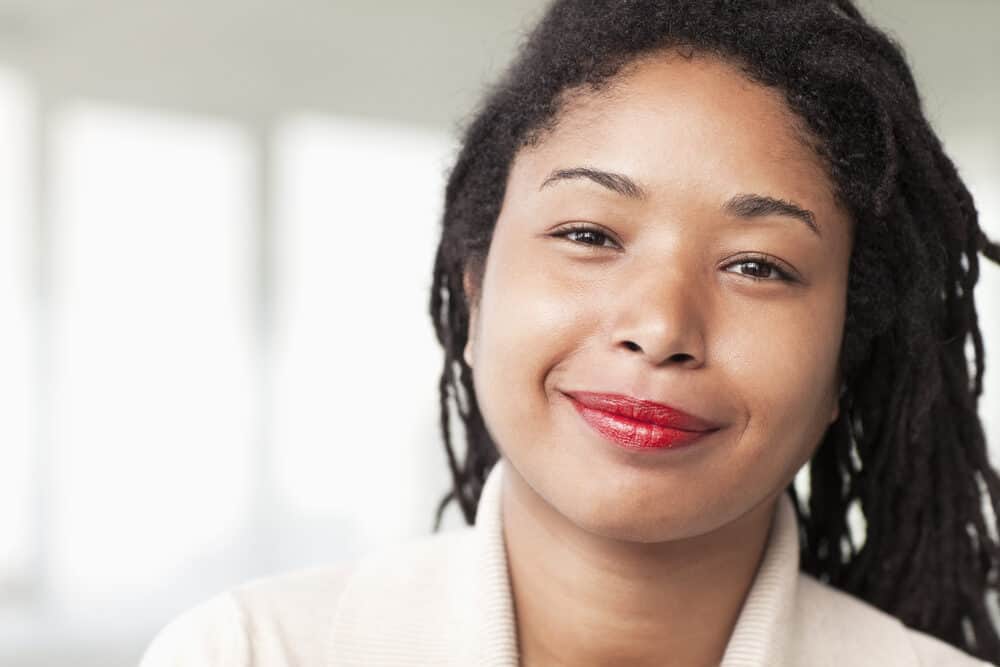 African American woman with red lipstick starting locs with two-strand twists