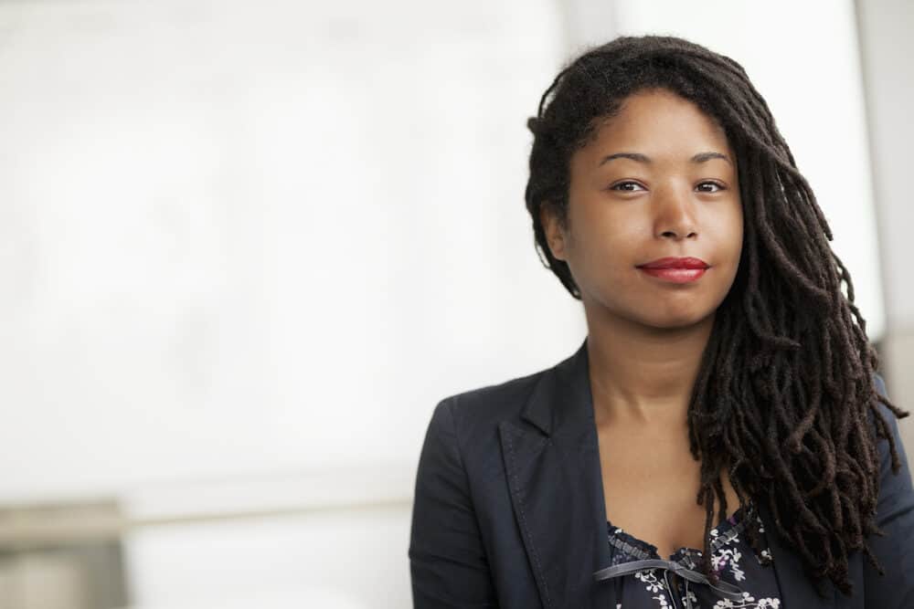 Black lady wearing single strand twists locs started with the two-strand method