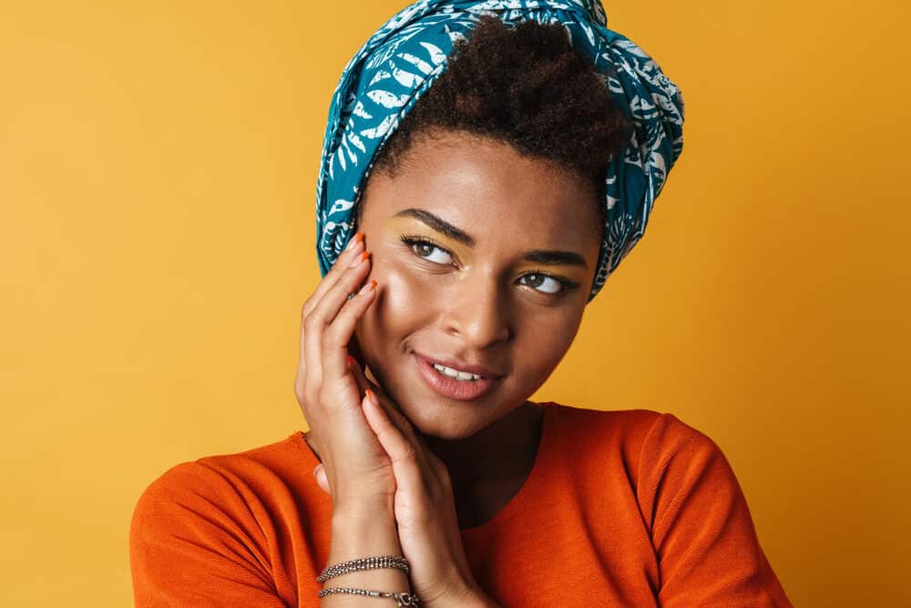 Black girl wearing a blue headscarf to protect her hair's very precious moisture content