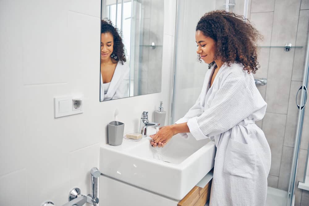 African American lady with ombre curly hair wearing a bathroom to absorb moisture