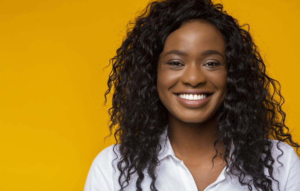 Black woman with weave hair extensions sewed to her own hair