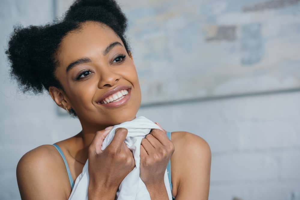 African American female wearing an afro puff style on her naturally curly hair