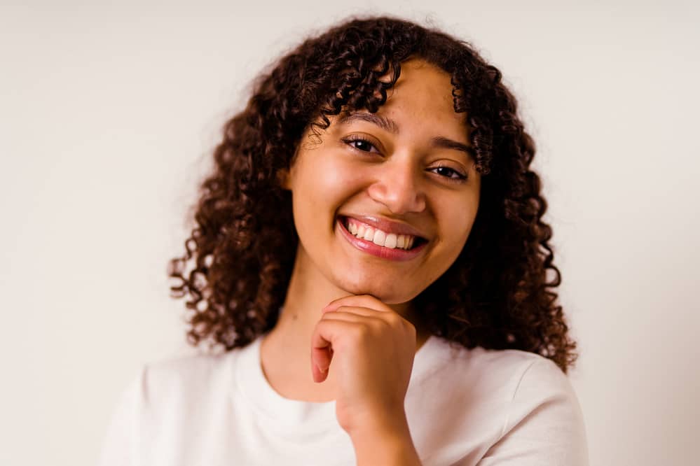 Black women wearing false eyelashes and curly extensions with hair extension glue