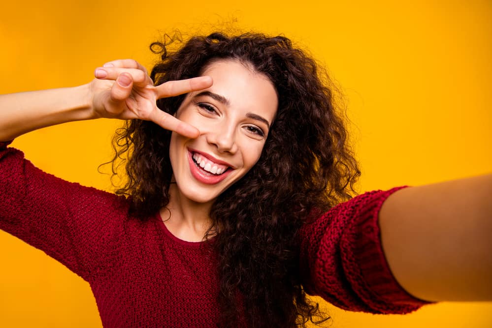 White girl with wavy natural hair after using perm rods to create loose and tighter curls