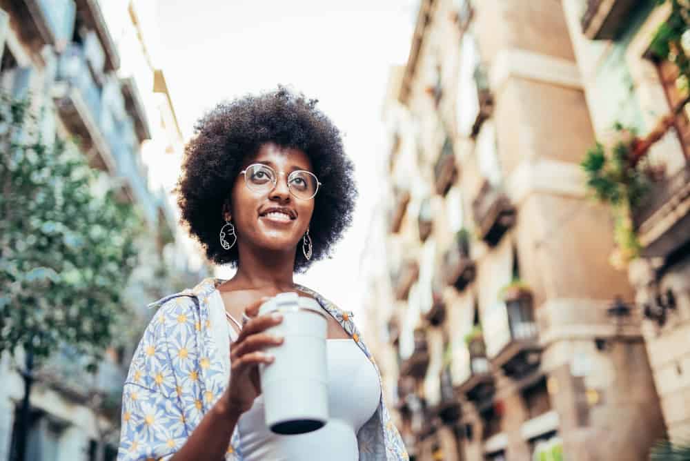 Young lady drinking tea posing for a photo after using a sulfate-free shampoo