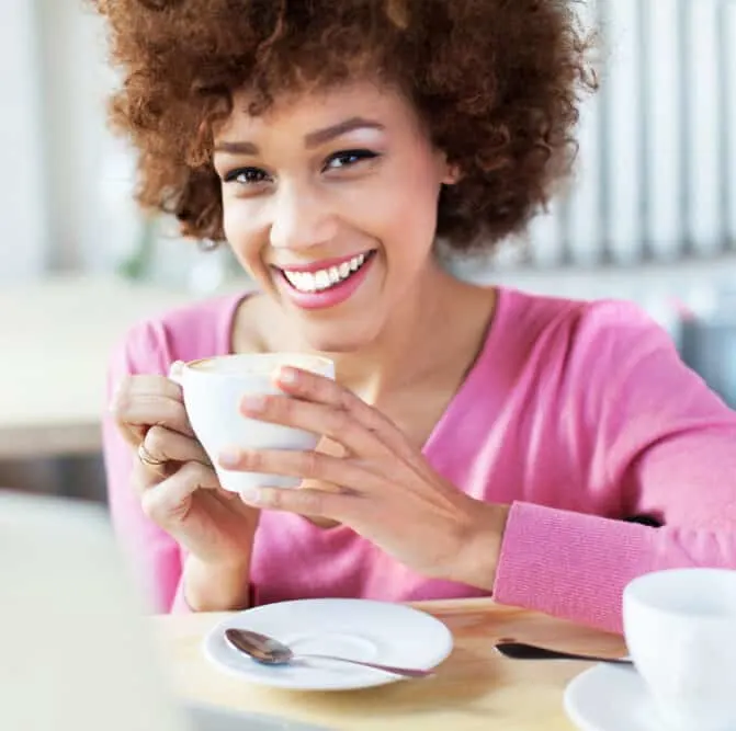Lady drinking coffee with semi-permanent dye in ginger curls