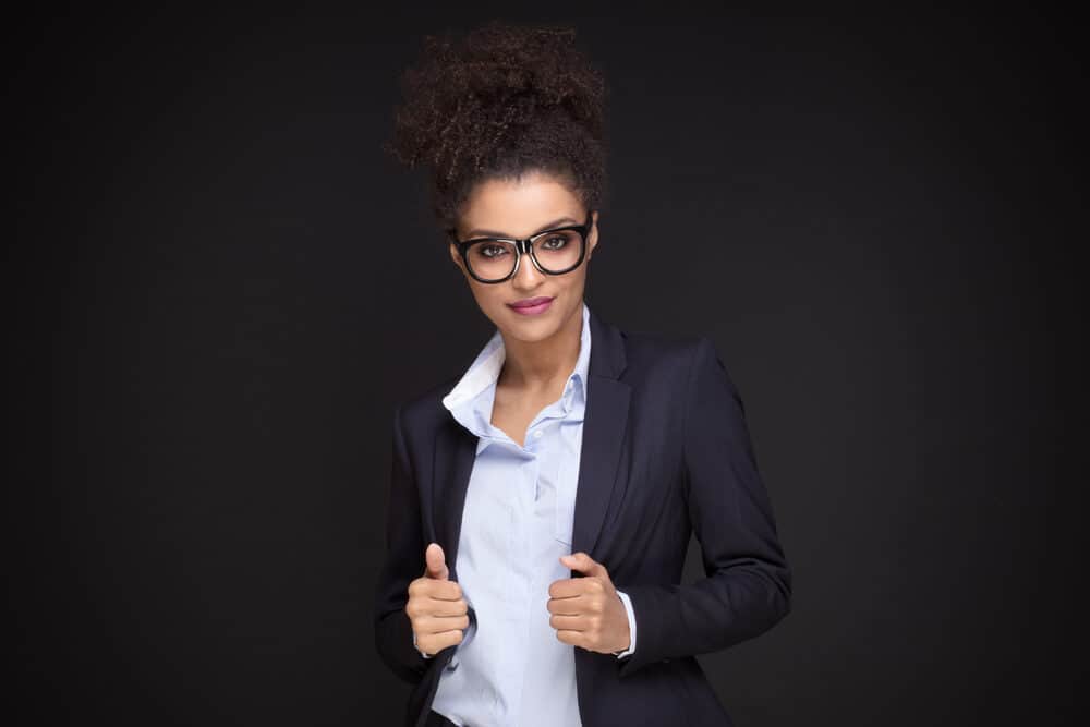 Black girl in a business suit preparing for a job interview with long hair in a curly hairstyle