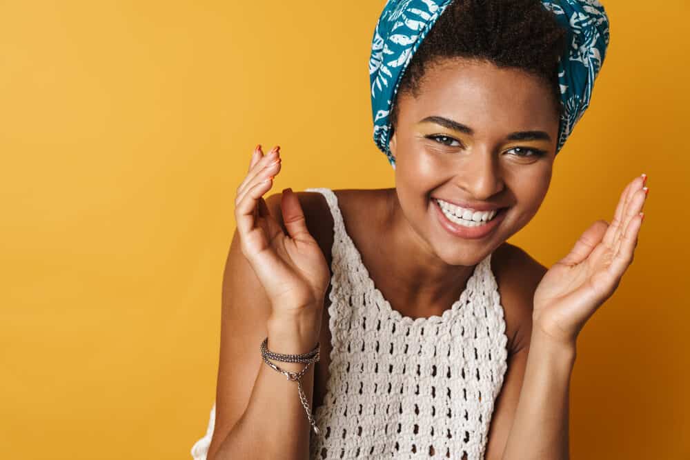 Cheerful African American curly girl wearing a protective style red fingernails and lipstick