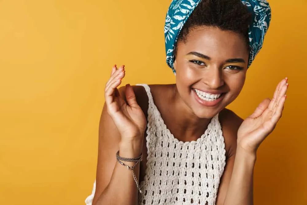 How To Get Dandruff Out of Curly Hair Quickly at Home 1 Cheerful African American curly girl wearing a protective style red fingernails and lipstick