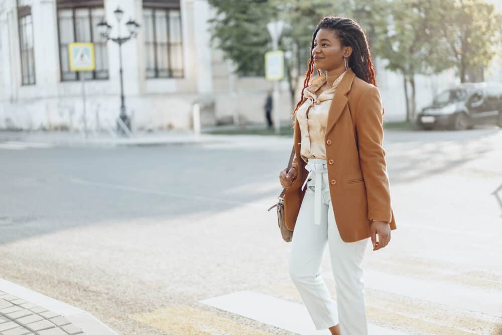 Young woman walking on the street with stray hairs peaking through dreadlocks