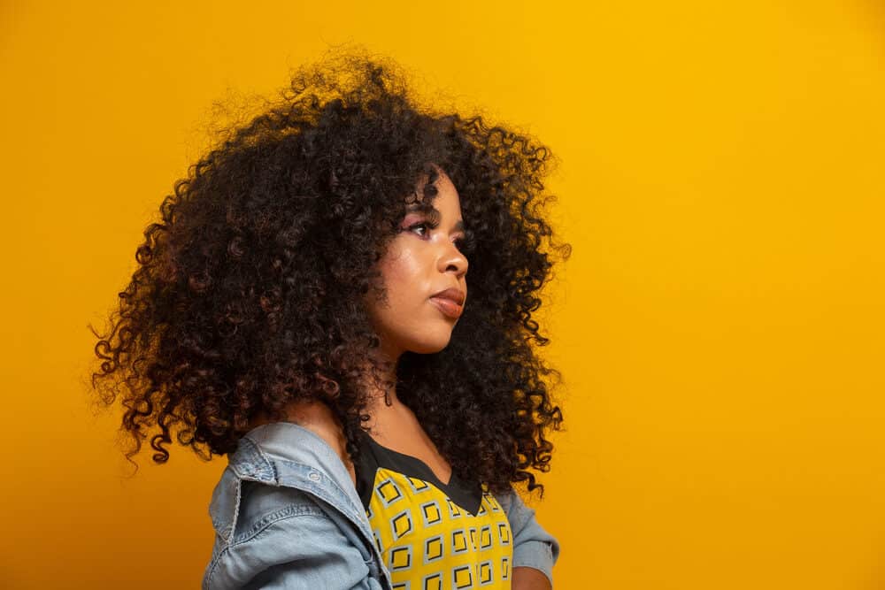 Cute brown-skinned black girl wearing amazing curly natural hair extensions 
