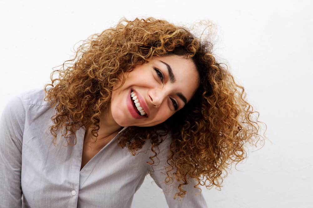 Attractive young woman with color-treated hair after using toning drops