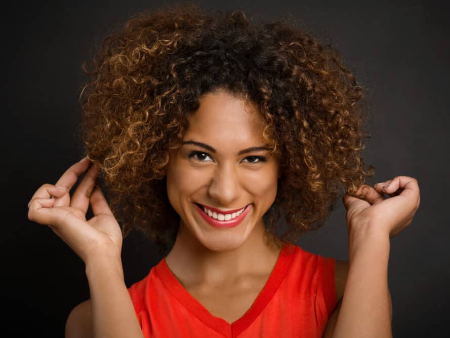 Black girl with bouncy ombre curls after using argan oil and leave-in conditioner styling products