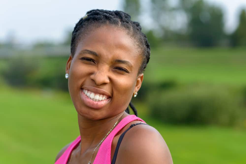 Black woman with a big smile that hasn't washed her dirty dreadlocks regularly to remove residue