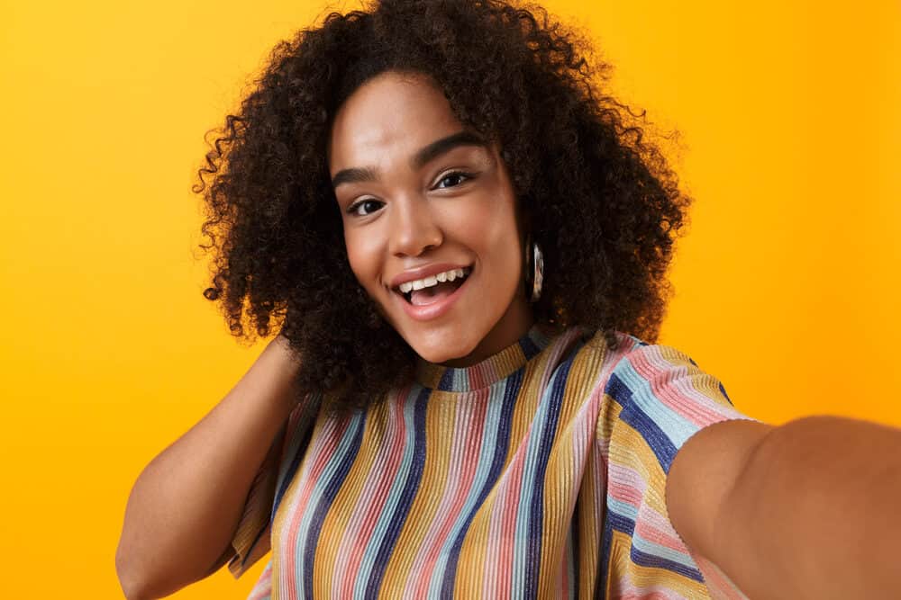 Cute young black woman with curly nape hair wearing a colorful casual shirt