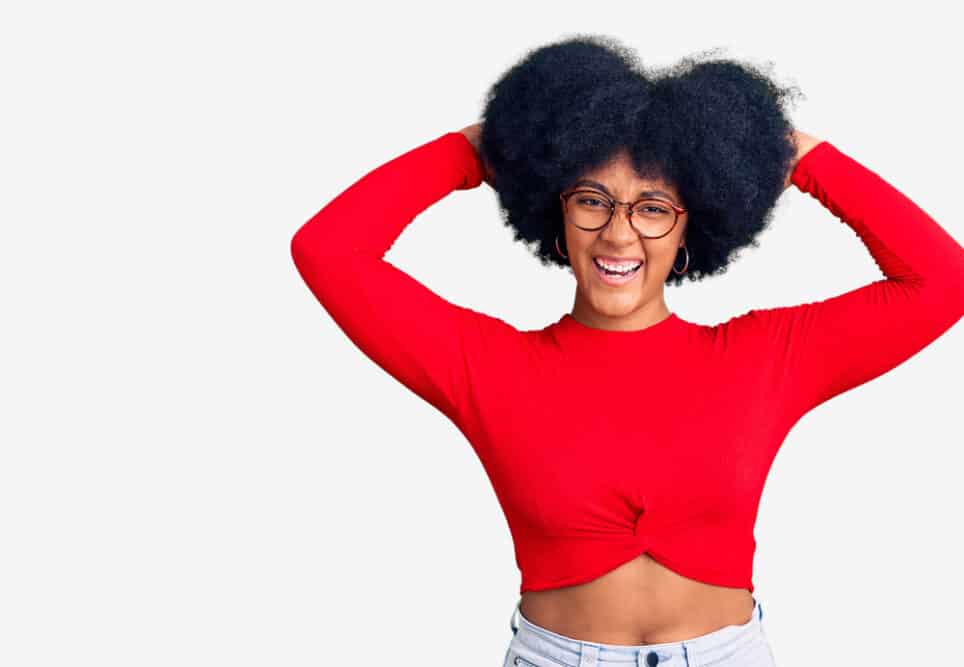 African American lady rubbing a conditioning agent through her curls to reduce frizz