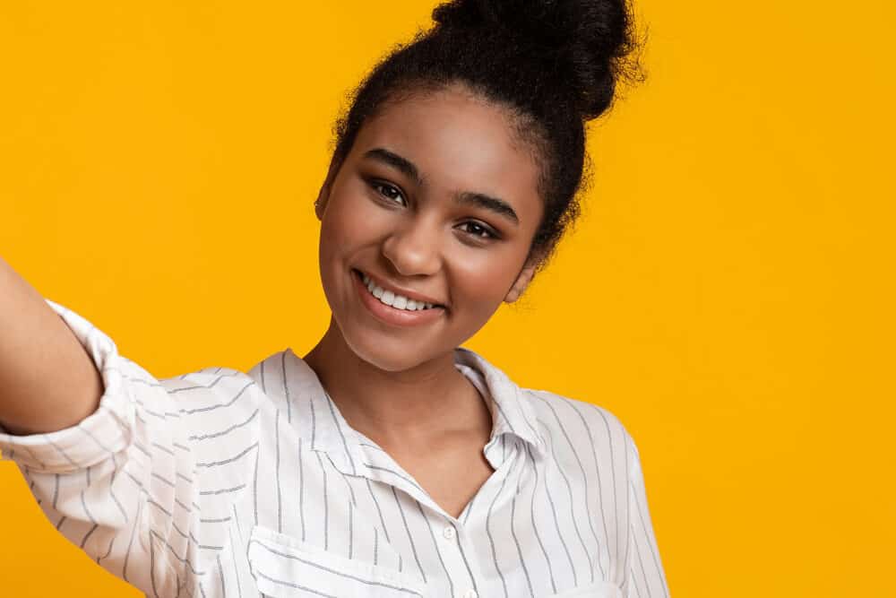 Black girl wearing a white and silver dress shirt with type 3 hair type