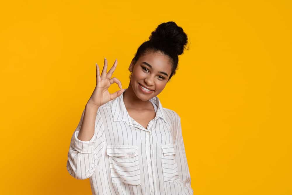 Cute African American female showing-off her hair after using sulphate-free shampoo