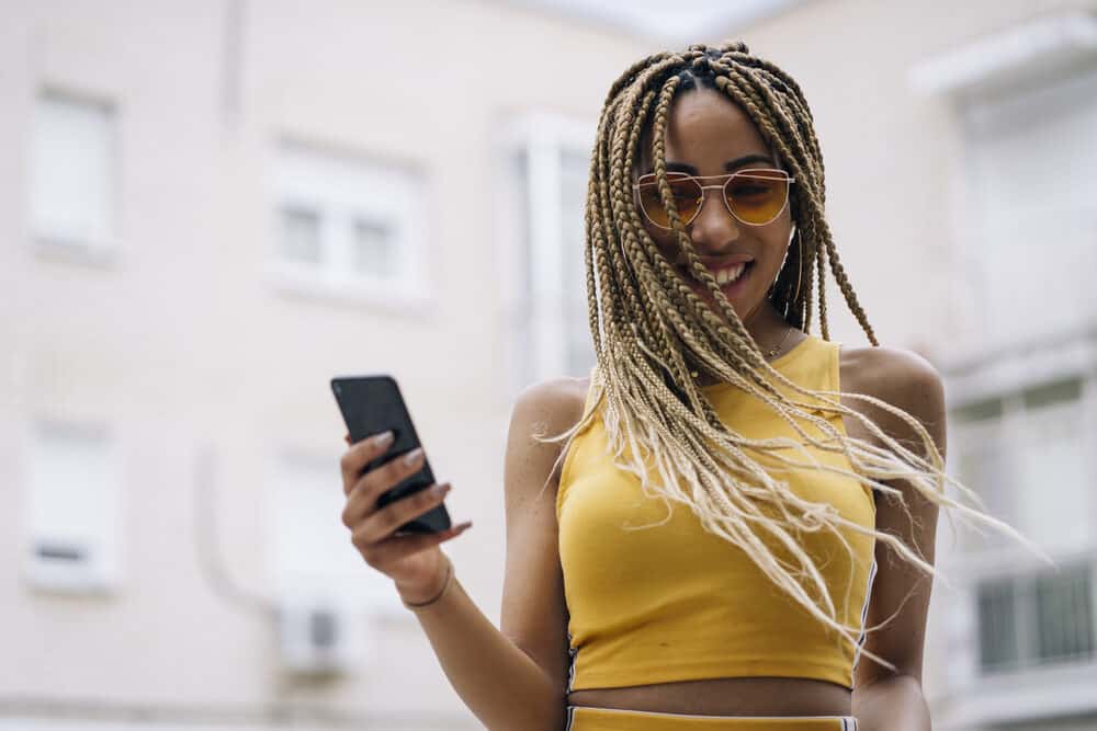 Pretty African girl with braided stretched hair wearing a yellow casual outfit