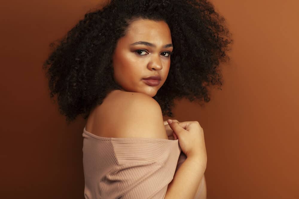 Pretty young black female with natural curls wearing red lipstick and neutral make-up